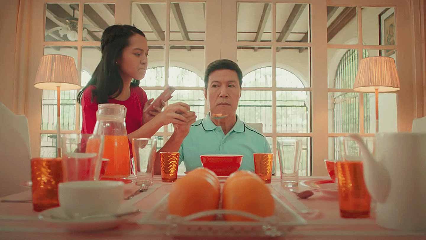 Screenshot of the PSBank TVC featuring a daughter force feeding her father.